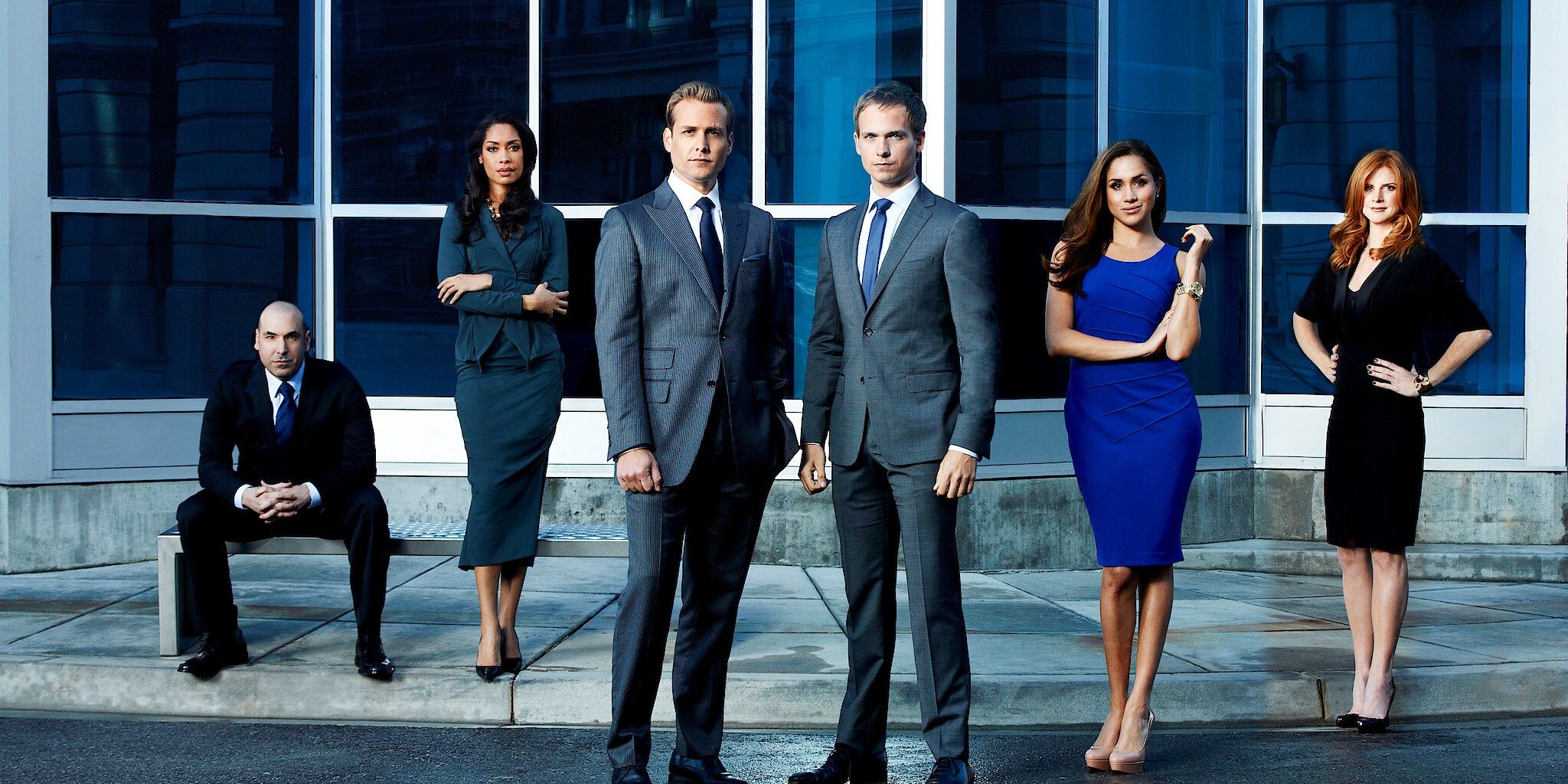 The original ensemble cast of Suits standing in front of a building
