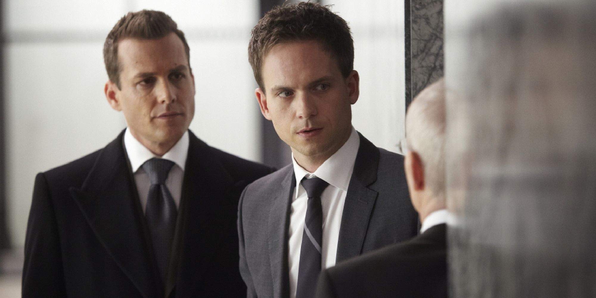 Mike Ross standing with Harvey Specter behind him in Suits 