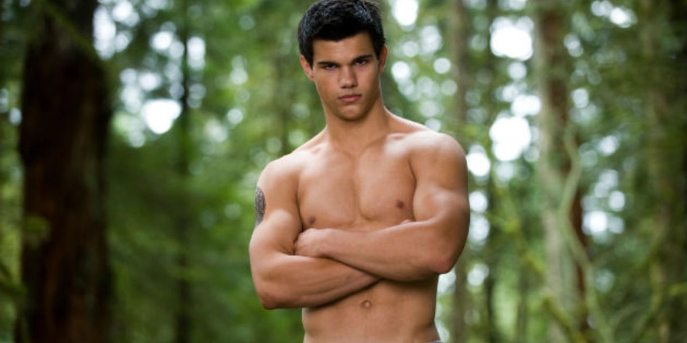 Taylor Lautner como Jacob em Eclipse, sem camisa e com os braços cruzados