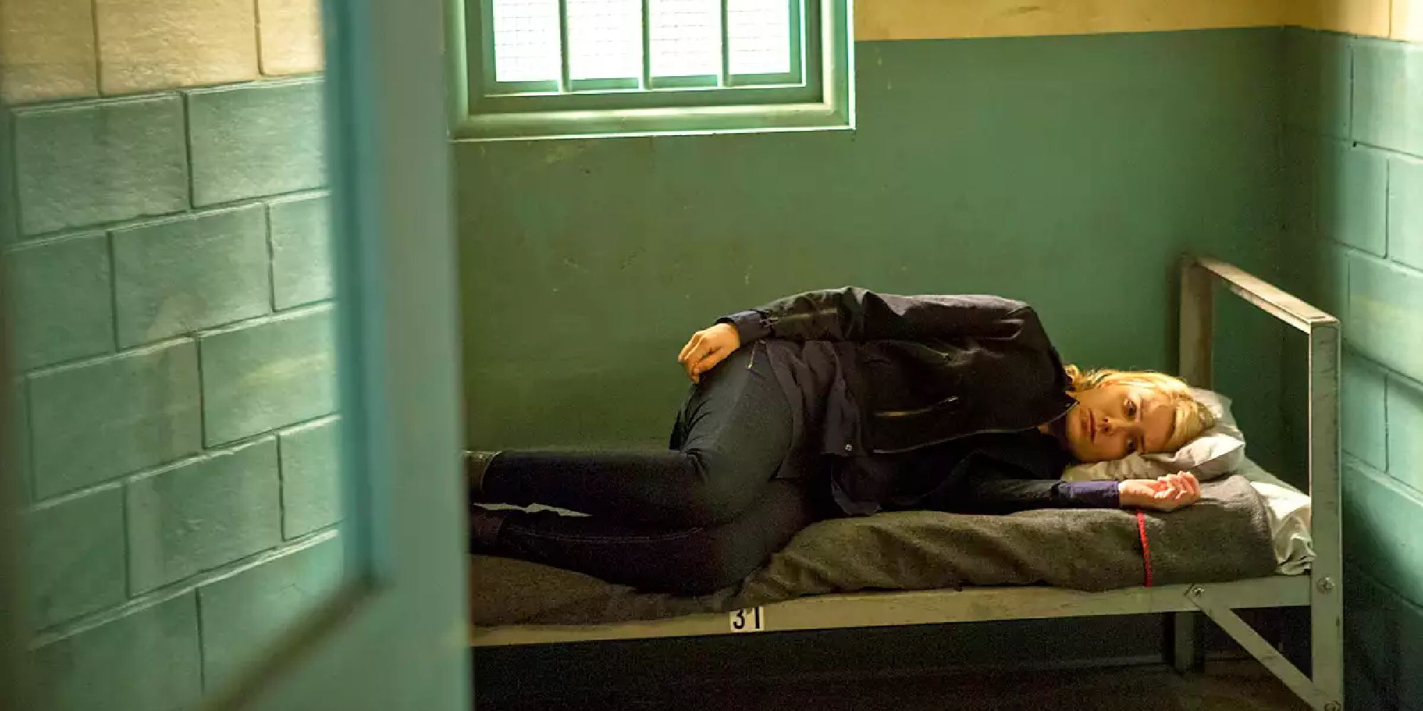 Elizabeth Keen allongée dans son lit dans une cellule de prison