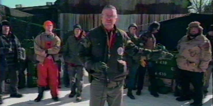 Still from VHS/94: a group of men give a presentation to the camera.