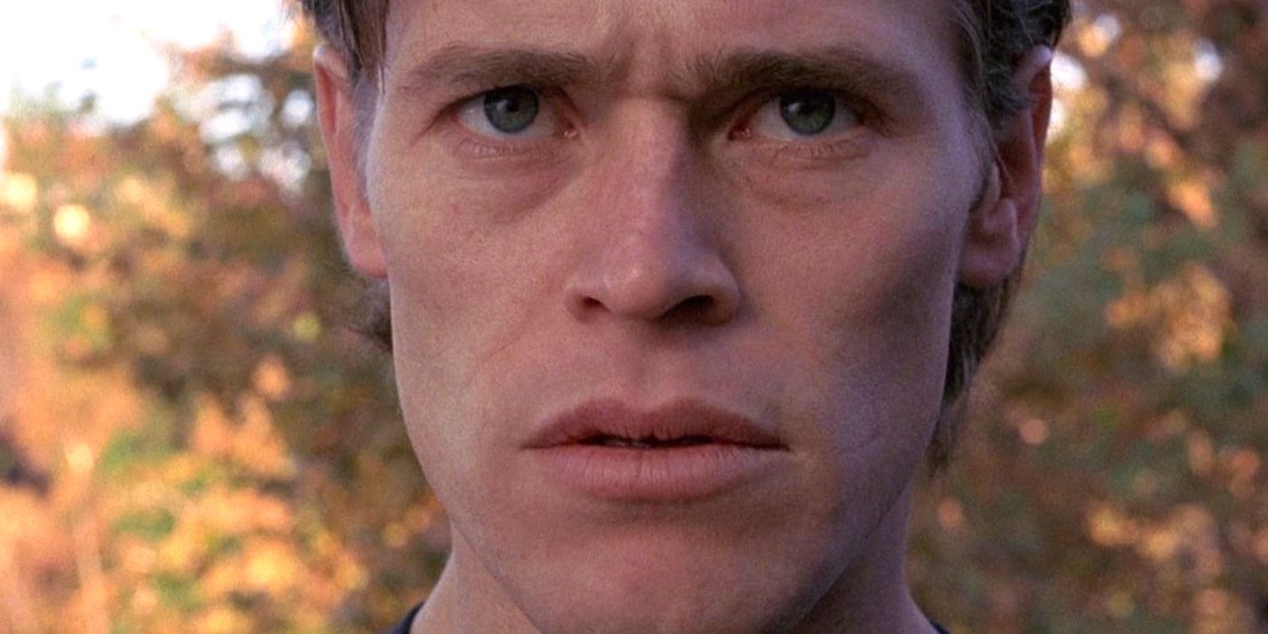 Primer plano de Willem Dafoe con el ceño fruncido y mirando hacia adelante en 