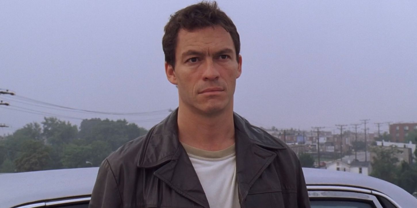 James McNulty (Dominic West) looks over the city of Baltimore as he stands against his car.