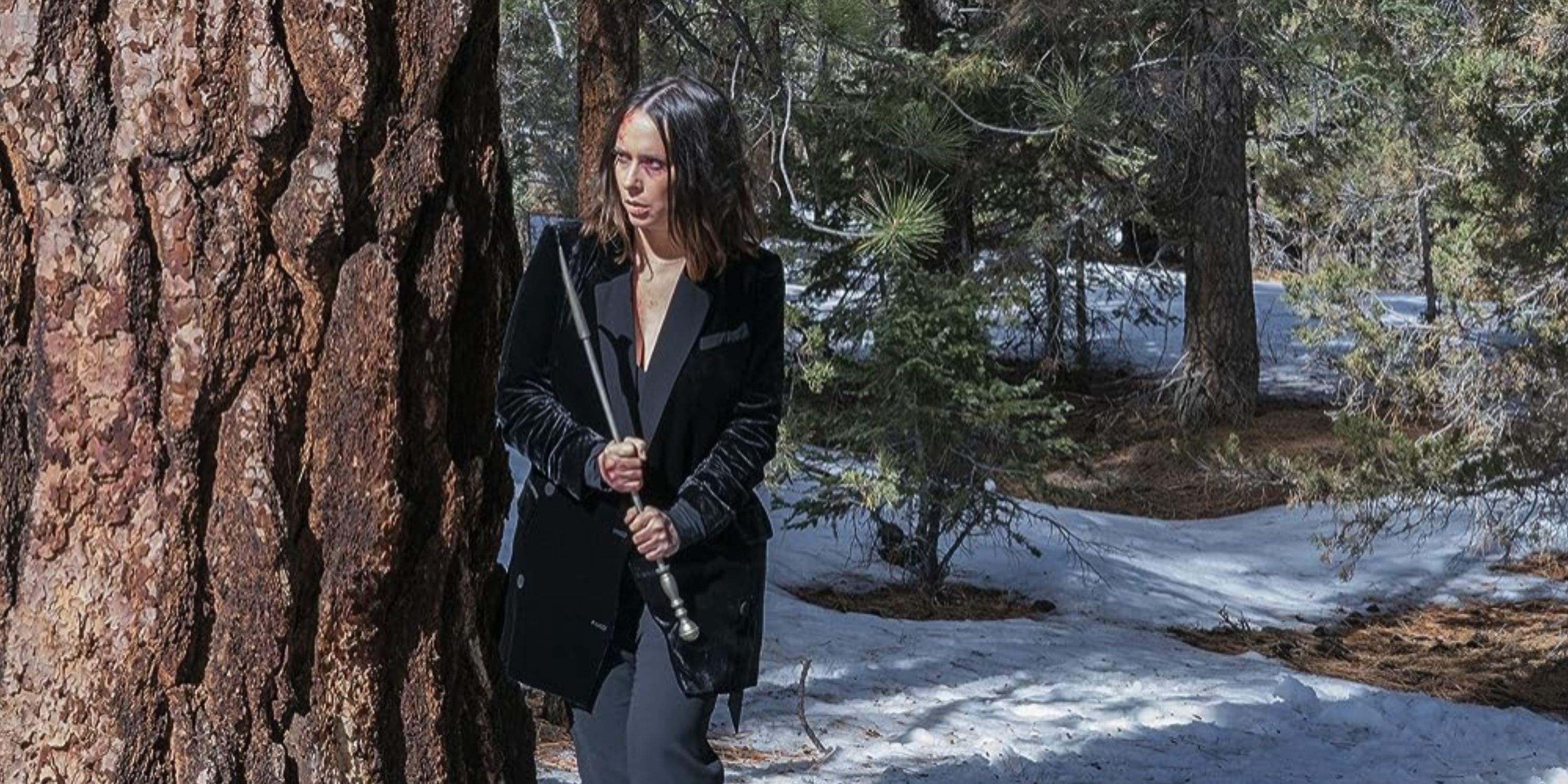 Maddie, standing next to a tree outside in the snow, holding a bat in '9-1-1.'