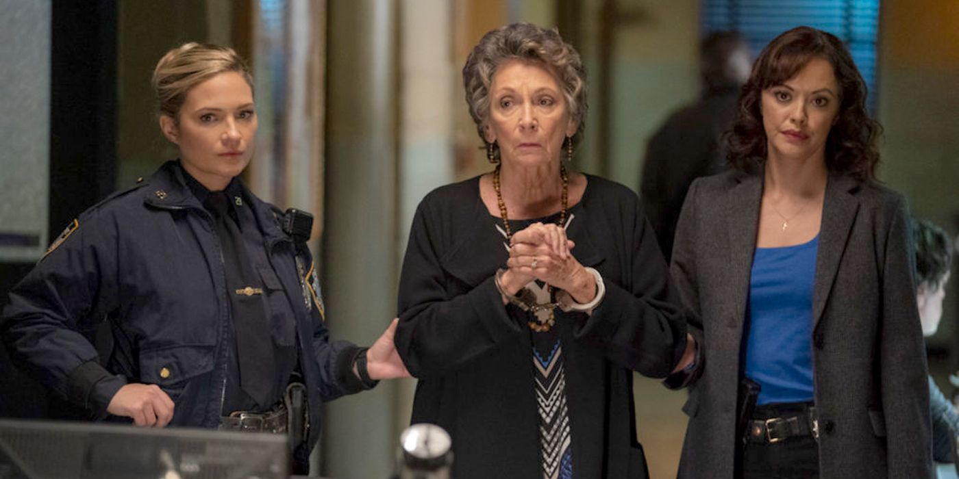 Eddie (Vanessa Ray) and Maria (Marisa Ramirez) walking with an older woman in handcuffs in Blue Bloods