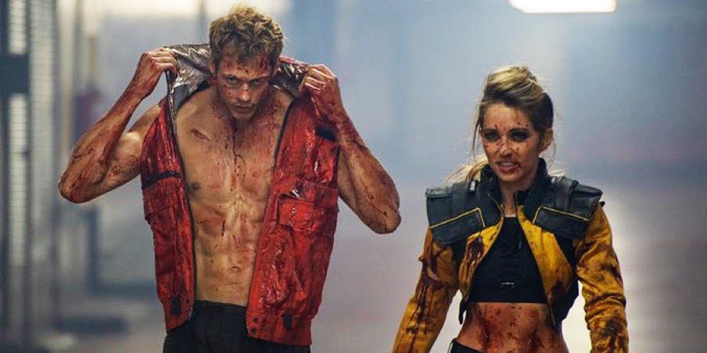 Bill Skarsgard and Jessica Rothe walking together while covered in blood in Boy Kills World