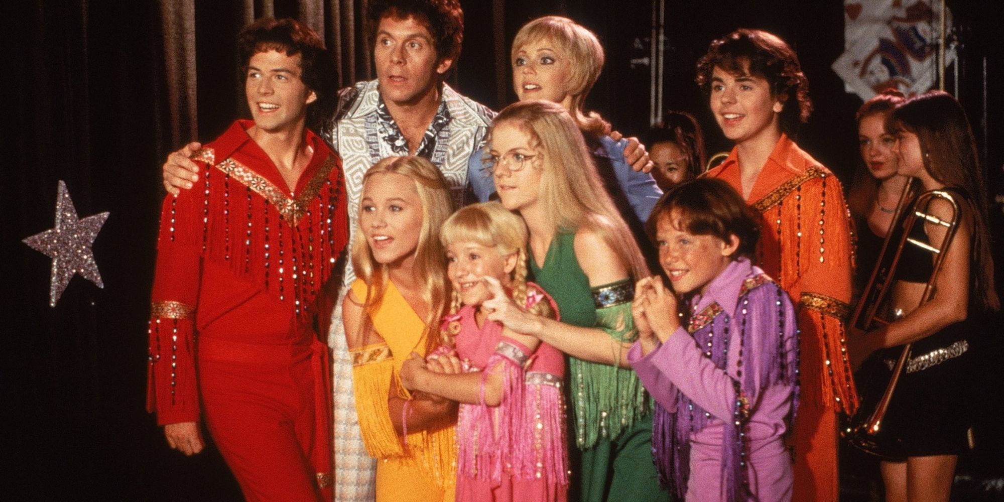 The cast of the Brady Bunch movie in 70s outfits