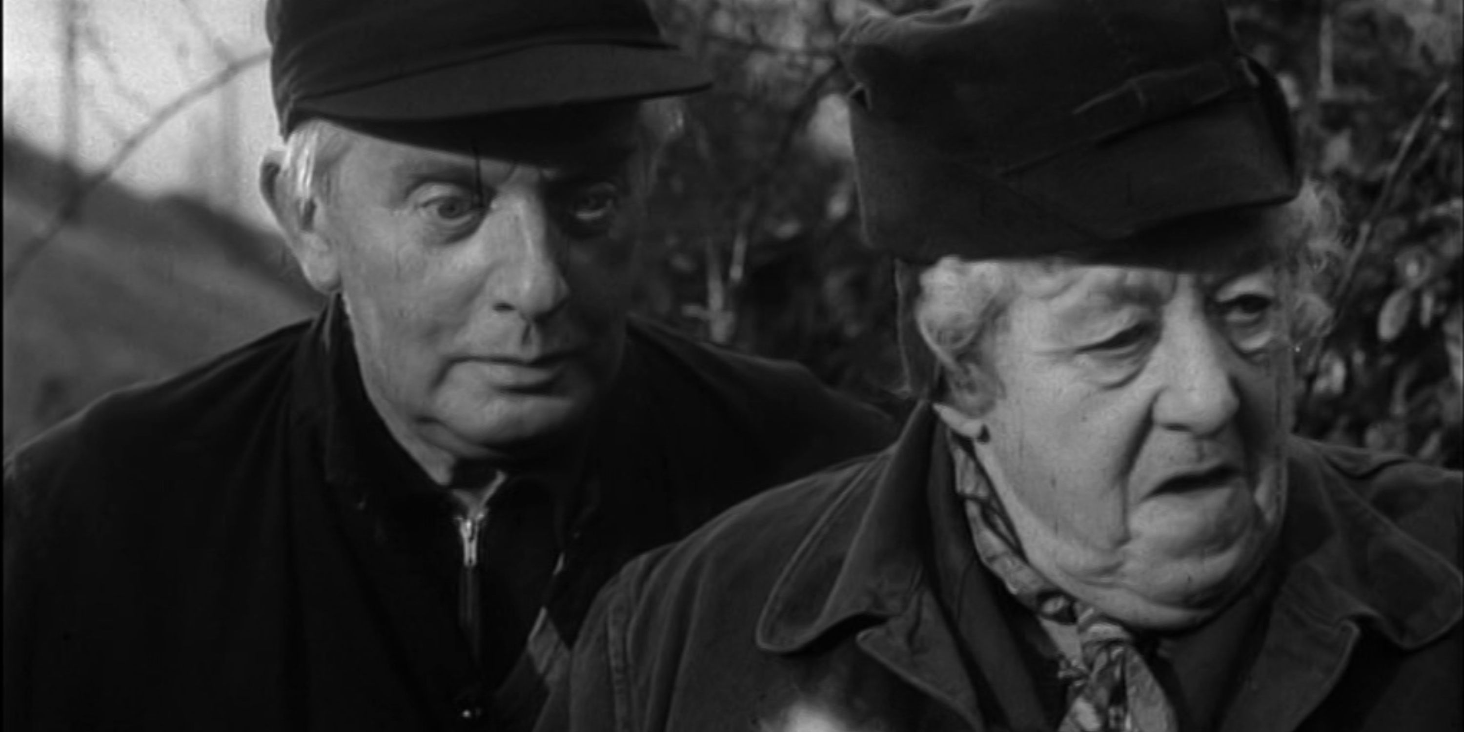 Miss Marple looks into the distance while a man stands behind her. 