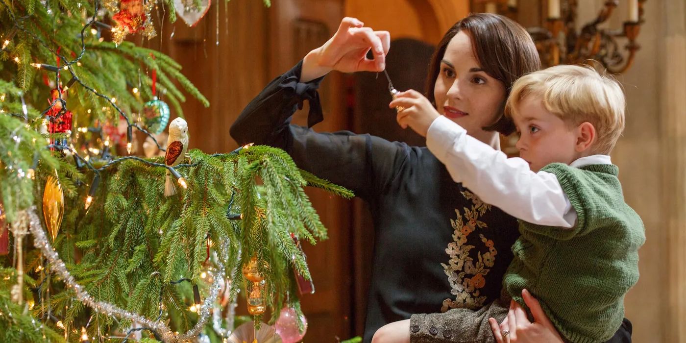 George (Oliver and Zac Barker) and Mary (Michelle Dockery) decorating a Christmas tree