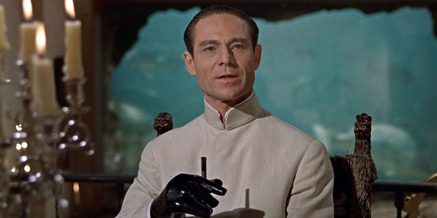 Dr. No holding a cigarette while talking to someone off-camera in the James Bond Film Dr. No