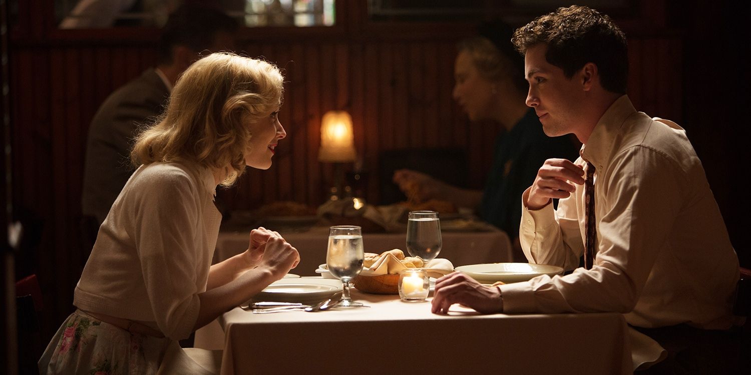 Logan Lerman as Marcus Messner sitting at a dinner table with Sarah Gadon as Olivia Hutton in Indignation