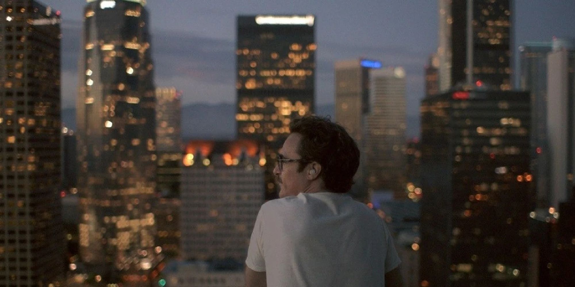 A shot of Joaquin Phoenix looking to the city lights in Her