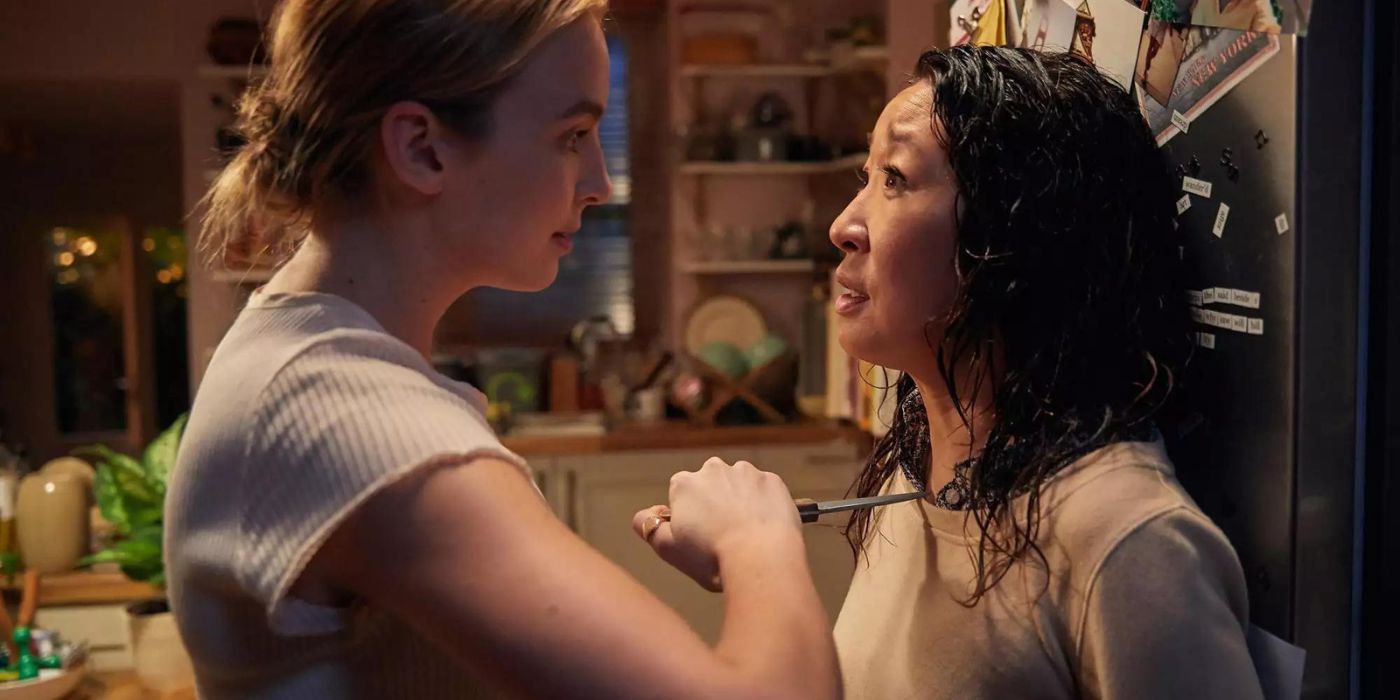 Jodie Comer as Villanelle holds a knife to Sandra Oh as Eve in the kitchen in Killing Eve.