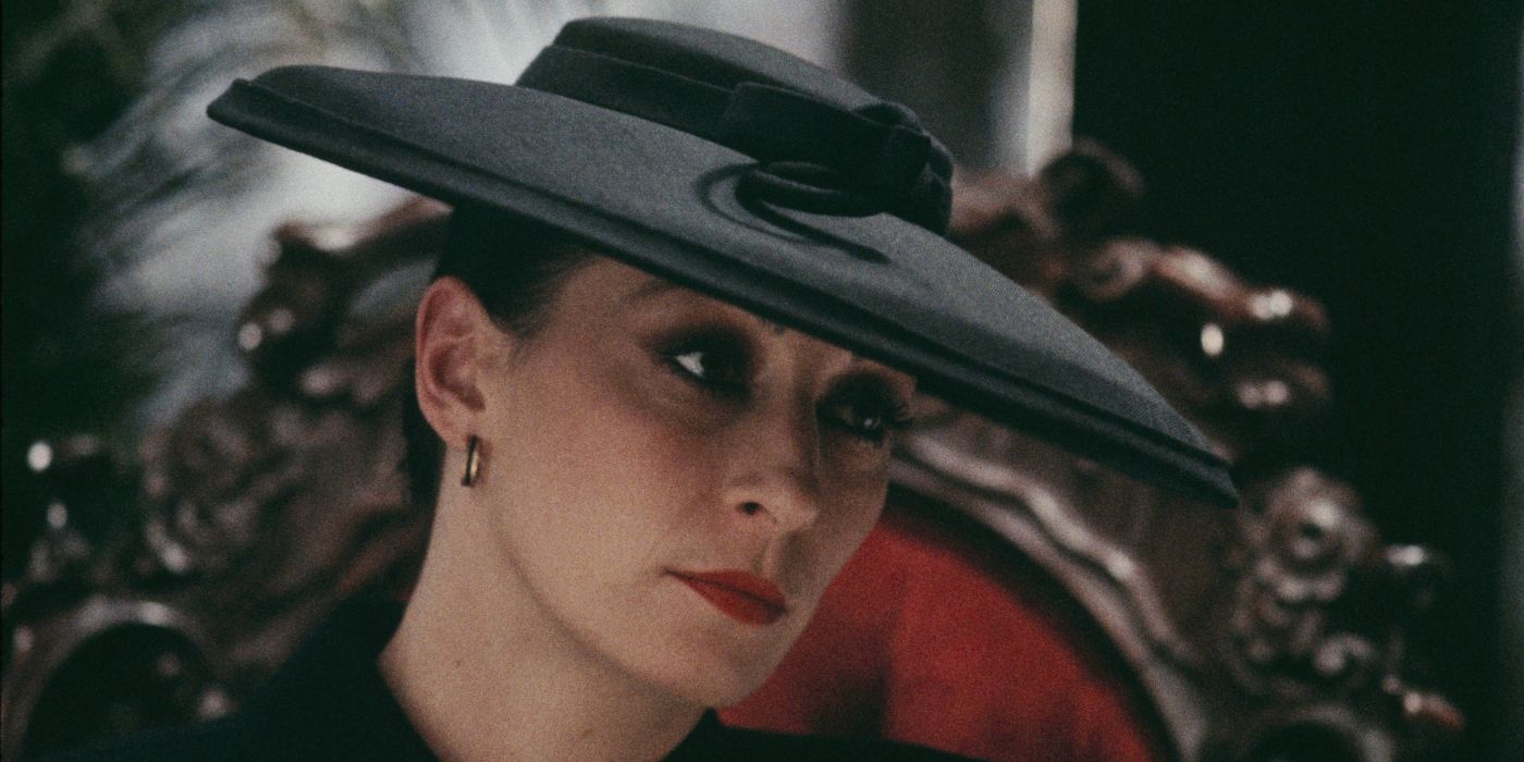 Close-up of Anjelica Huston wearing a black hat in Prizzi's Honor