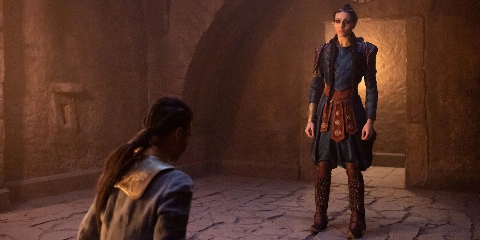 A woman standing before a kneeling man in The Wheel of Time