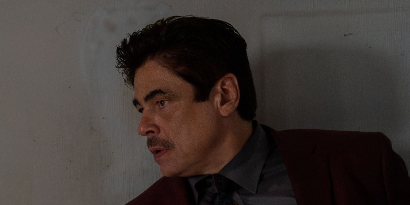 Benicio del Toro standing against a wall in Reptile 