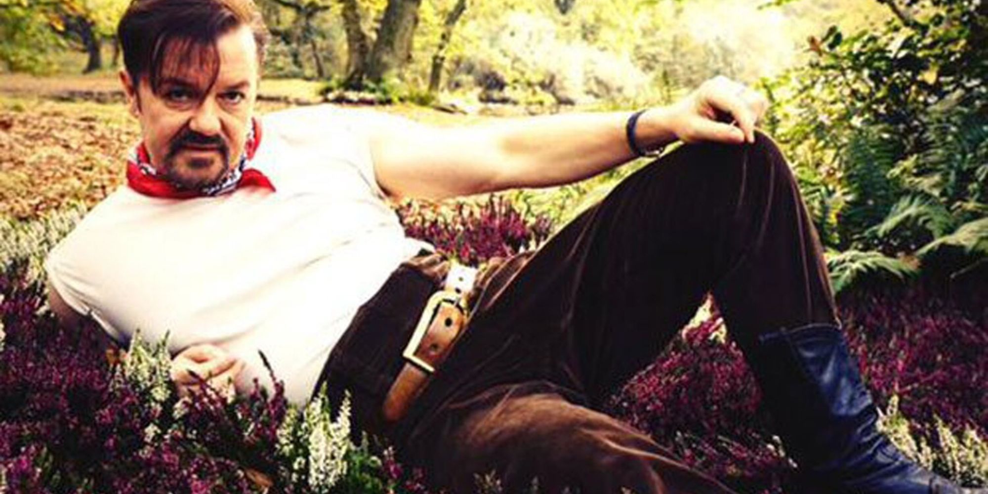 Ricky Gervais as David Brent lounging in a forest