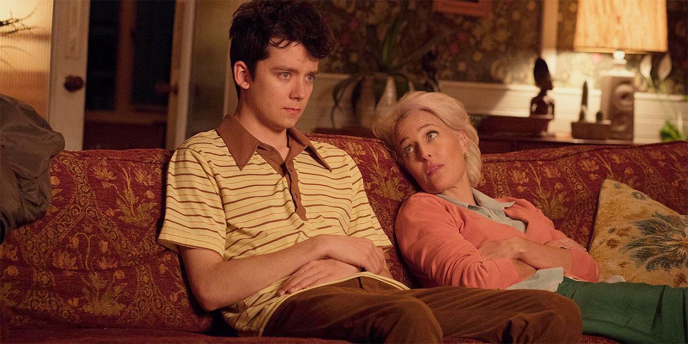 Asa Butterfield as Otis and Gillian Anderson as Jean sitting on the couch talking in Sex Education