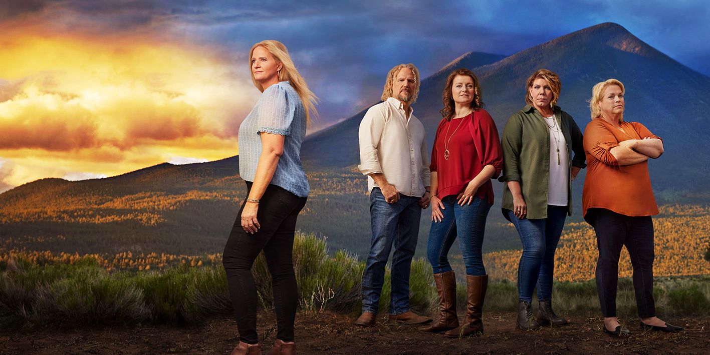 Sister Wives - Kody and wives stood next to each other with a sunset background