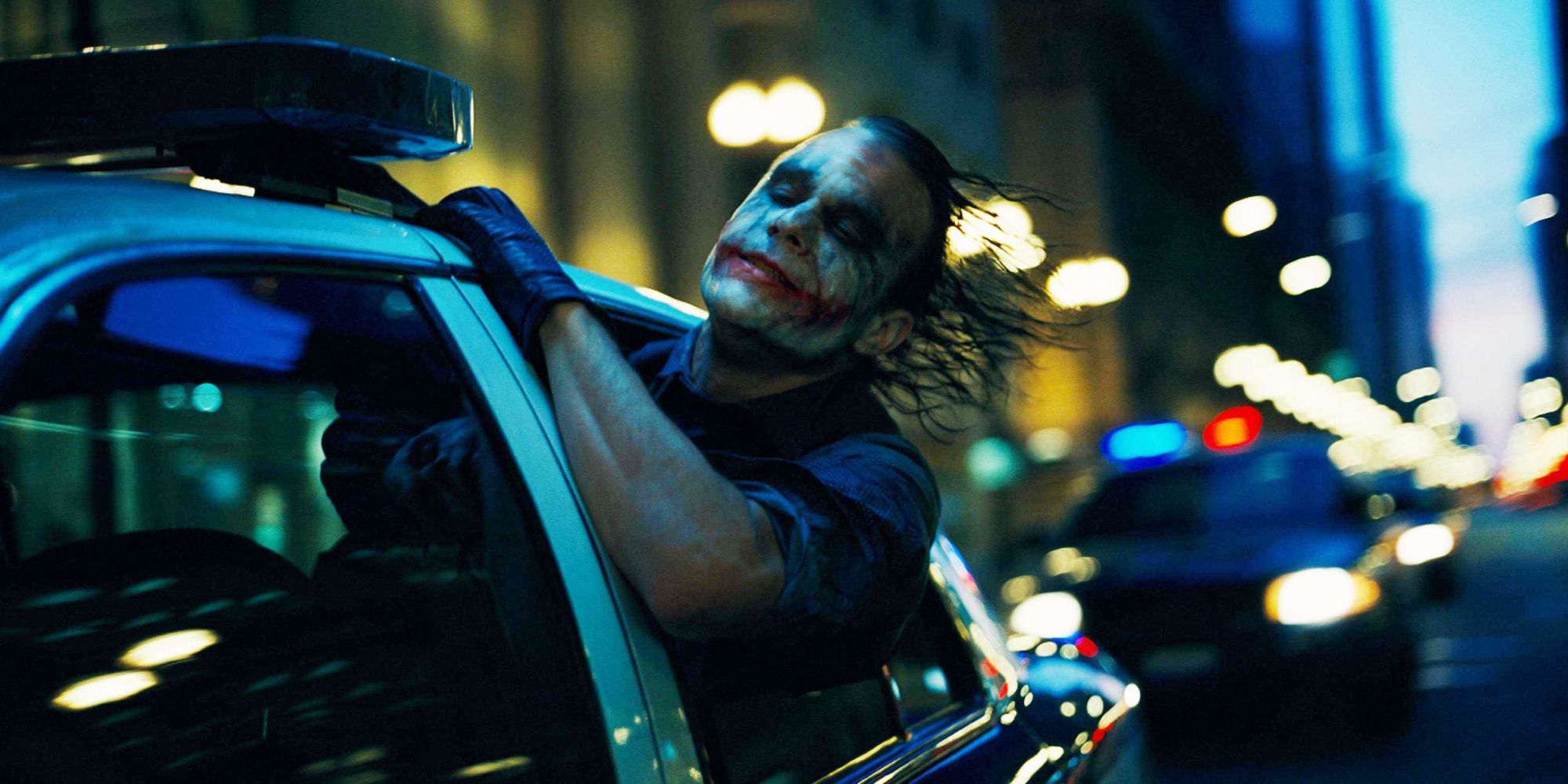 Heath Ledger as The Joker sticks his head out the window in The Dark Knight