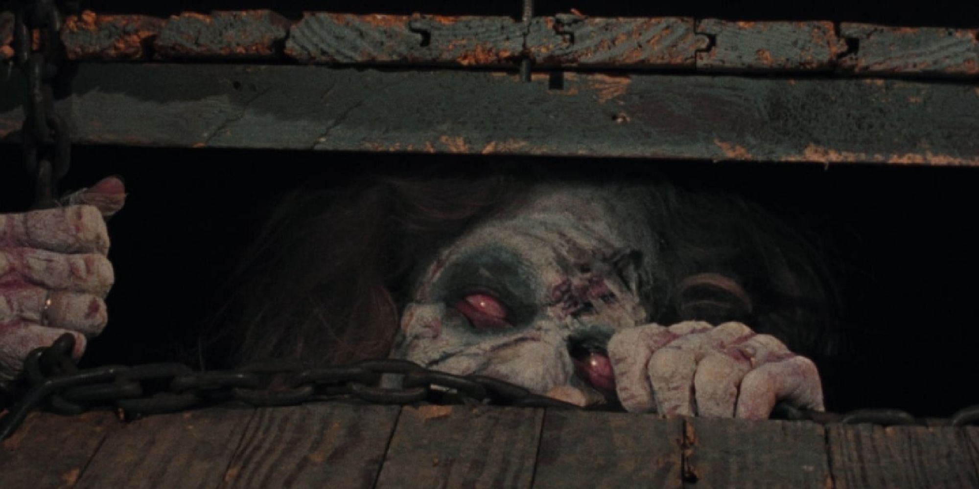 A deadite trying to come out from a basement cellar in The Evil Dead
