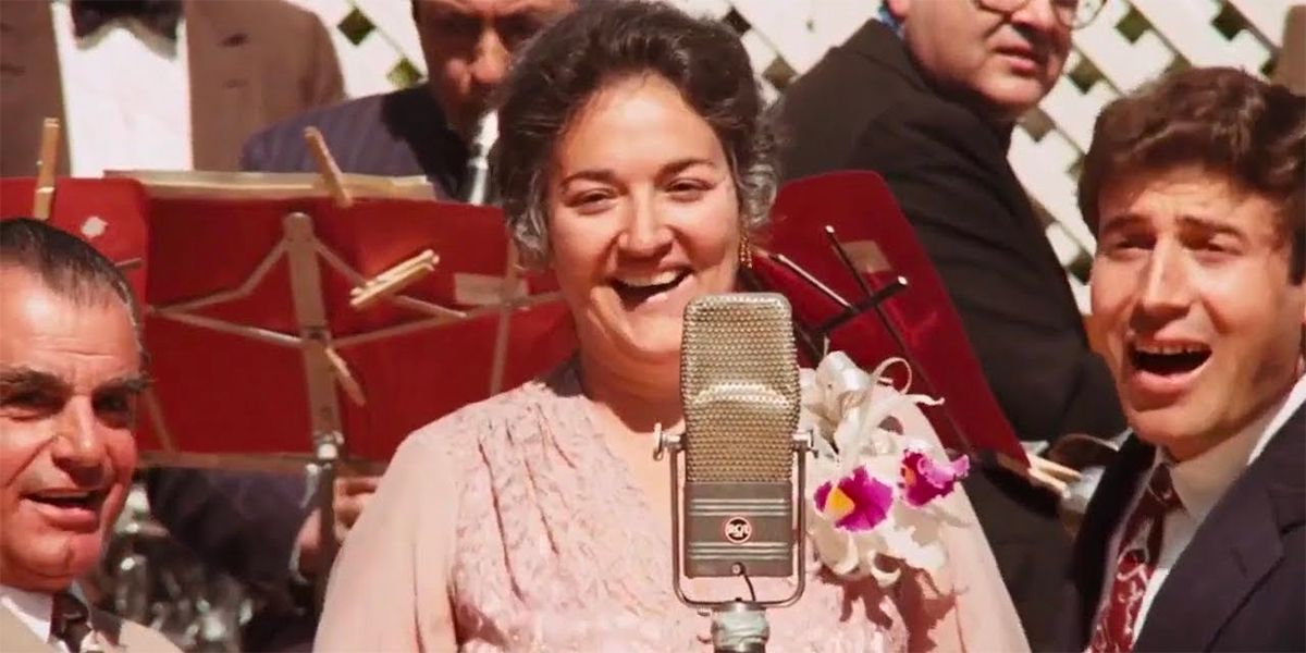 Morgana King as Carmela Corleone, standing at a microphone and singing in The Godfather