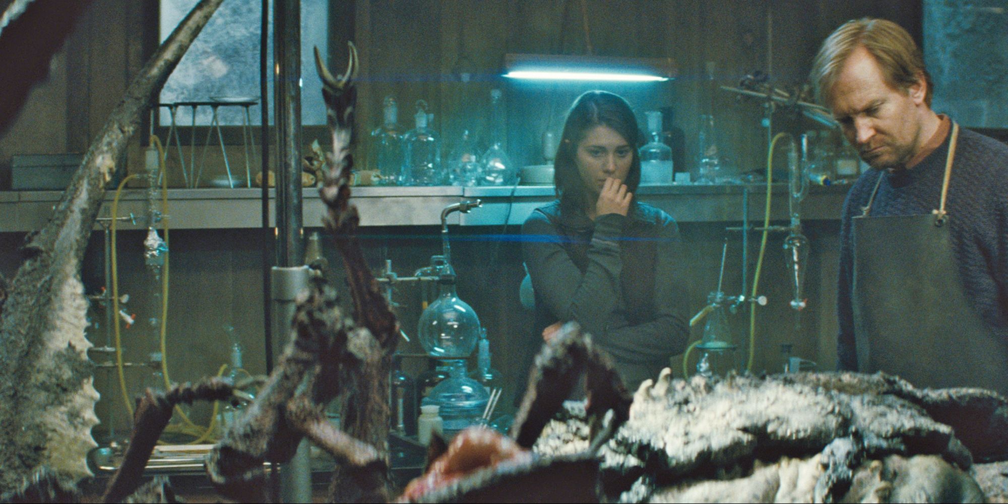 A man and a woman looking at a dead creature in The Thing