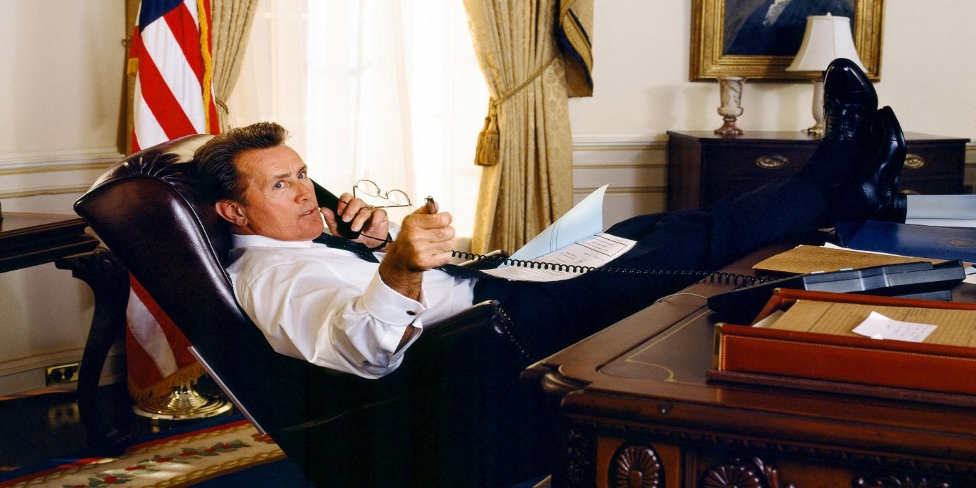 Martin Sheen as Josiah Bartlett talking on a phone with his feet on a desk in the Oval Office on The West Wing.