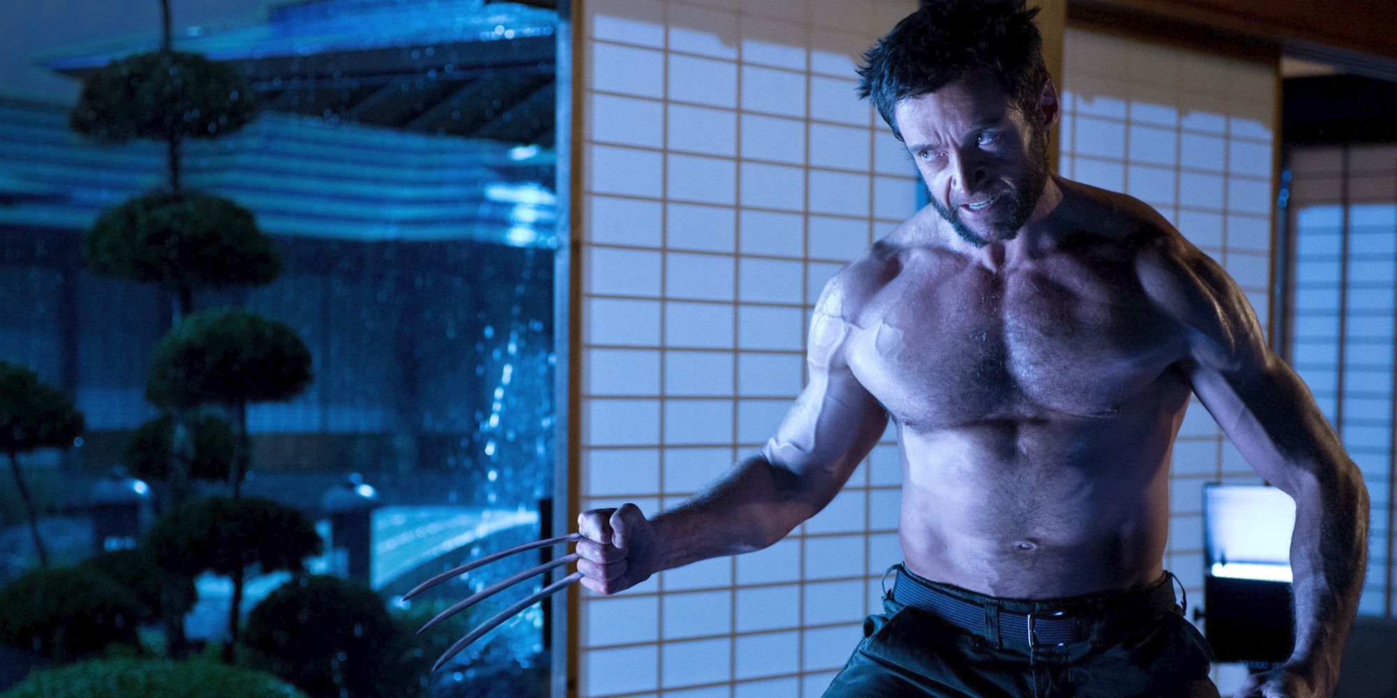 Hugh Jackman interpreta a Wolverine, sin camisa y levantando sus garras en 