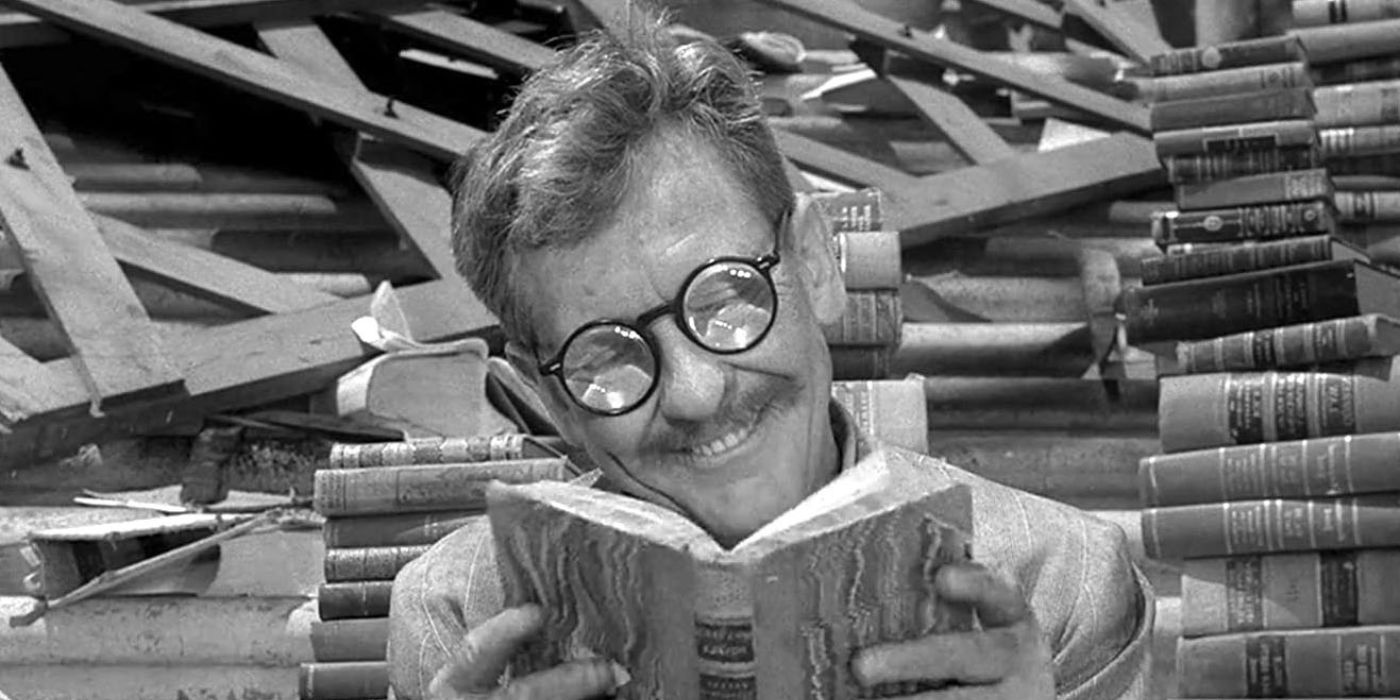 Burgess Meredith smiling and reading amongst a stack of books and debris in The Twilight Zone episode, Time Enough at Last