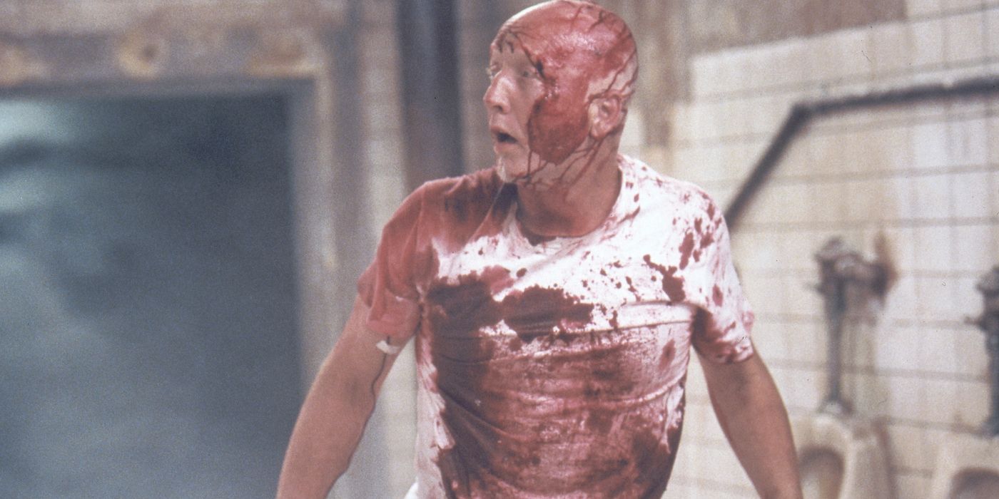 John Kramer, played by actor Tobin Bell, stands covered in blood in Saw.