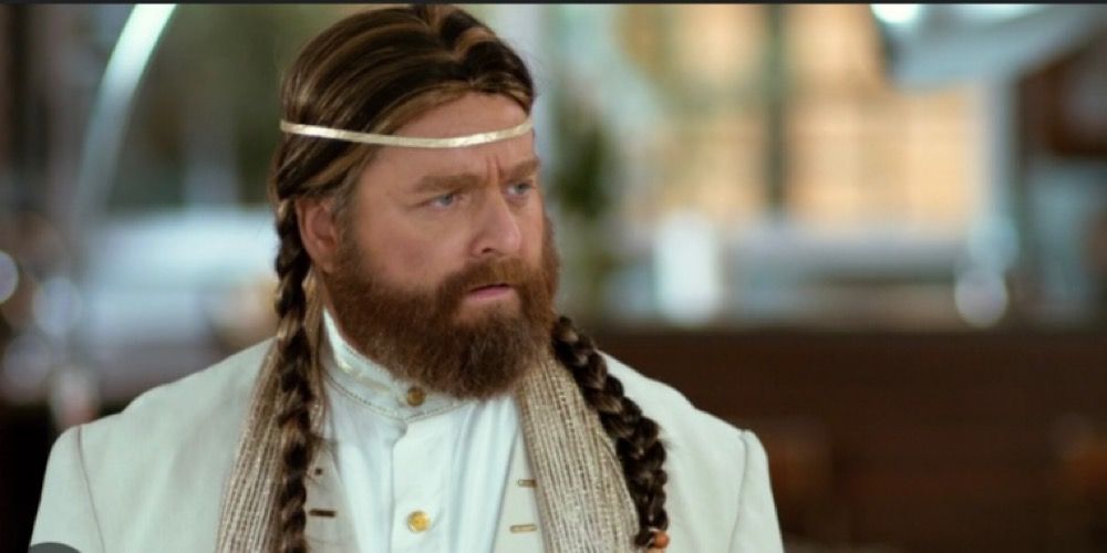 Zach Galifianakis dressed as Jim Joe Kelly wearing two braids and a guru outfit. 