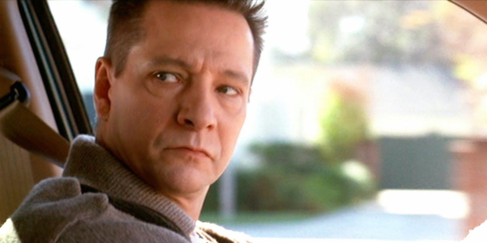 Chris Cooper as Col. Frank Fitts in a car looking to his right in American Beauty