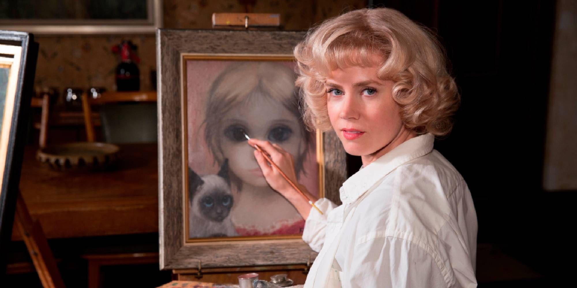 Amy Adams as Margaret Keane painting while turning around to face the camera in Big Eyes.