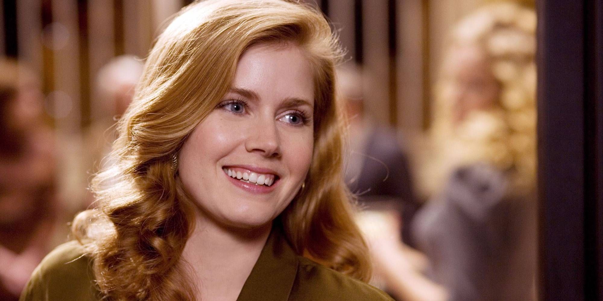 A close-up still of Amy Adams' character Bonnie Bach smiling in Charlie Wilson's War.