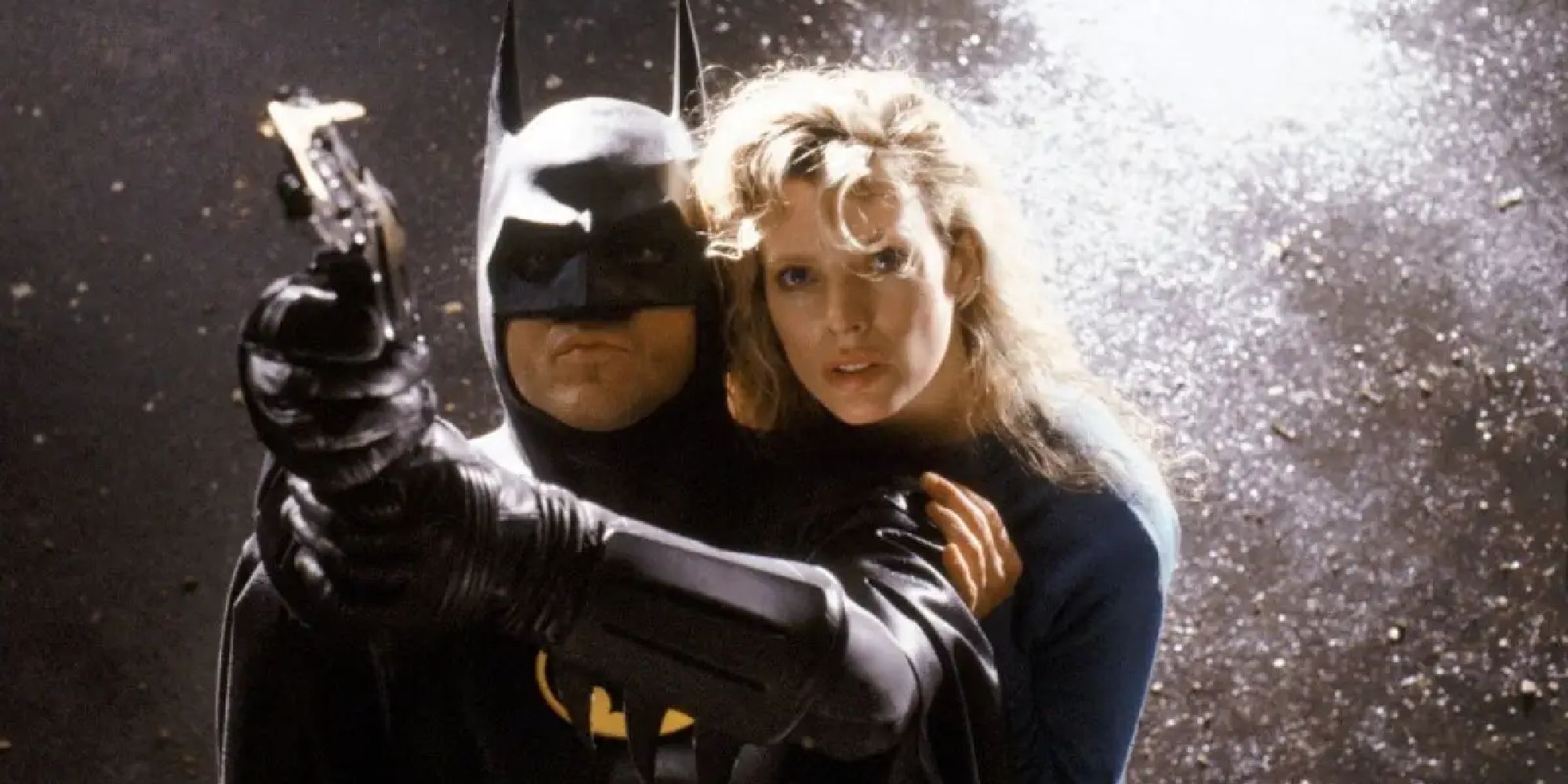 Michael Keaton y Kim Basinger como Batman y Vicki Vale intentan columpiarse desde un tejado en Batman - 1989