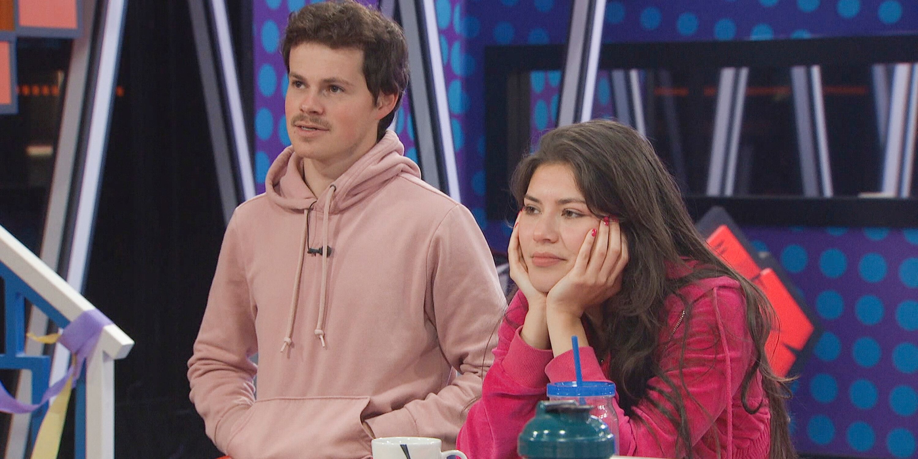Cory Wurtenberger and America Lopez listen to someone off camera in the 'Big Brother 25' kitchen.