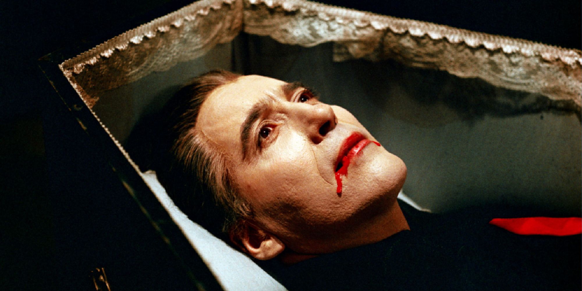 Christopher Lee as Count Dracula lying in a coffin with blood on his face in Dracula Has Risen from the Grave