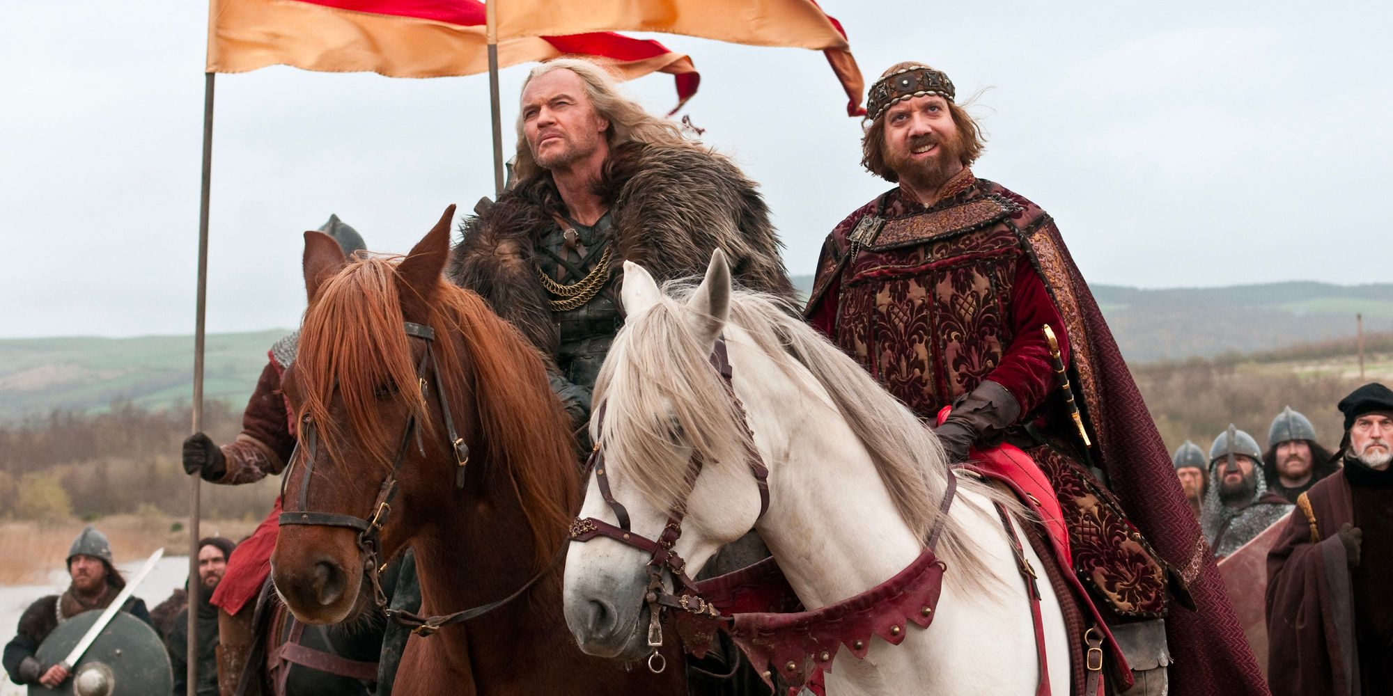 King John (Paul Giamatti) and his warrior accomplice ride their horses while being followed by a swarm of soldiers.