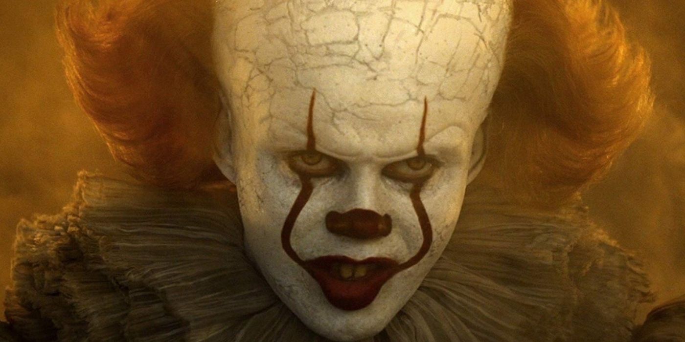 close up of Pennywise (Bill Skarsgard) with a yellow light from IT Chapter 2