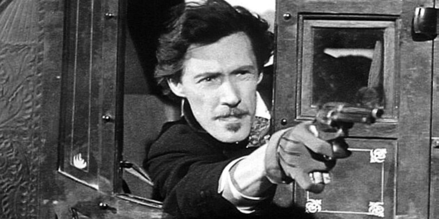 John Carradine hanging out the window of a stagecoach holding a pistol in Stagecoach (1939)