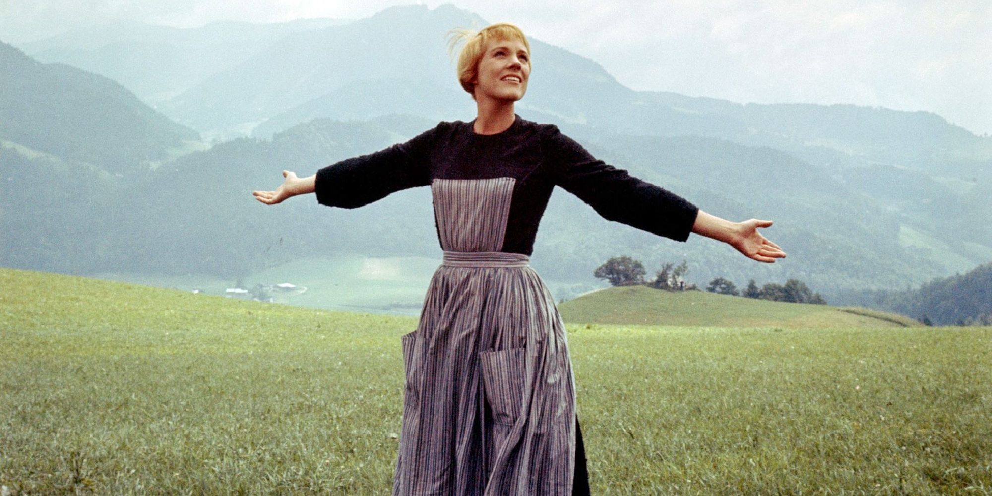 In ``The Sound of Music,'' Maria stands in a field, looking up at the sky and smiling with her arms outstretched.