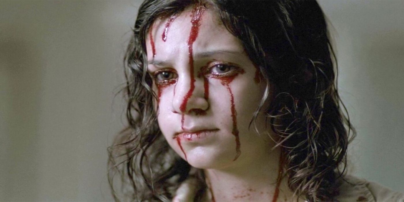 A bloodied young girl with brown hair looking at something concerned