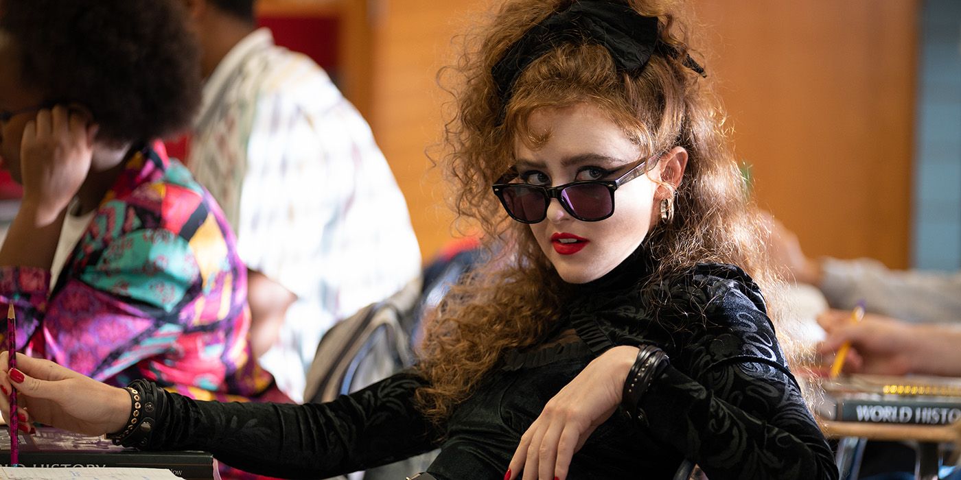 Kathryn Newton wearing sunglasses and sitting at a desk in Lisa Frankenstein