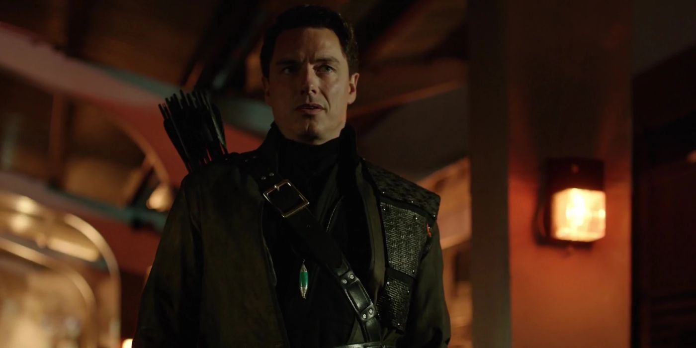 John Barrowman as Malcolm Merlyn looking intently off-camera in Arrow