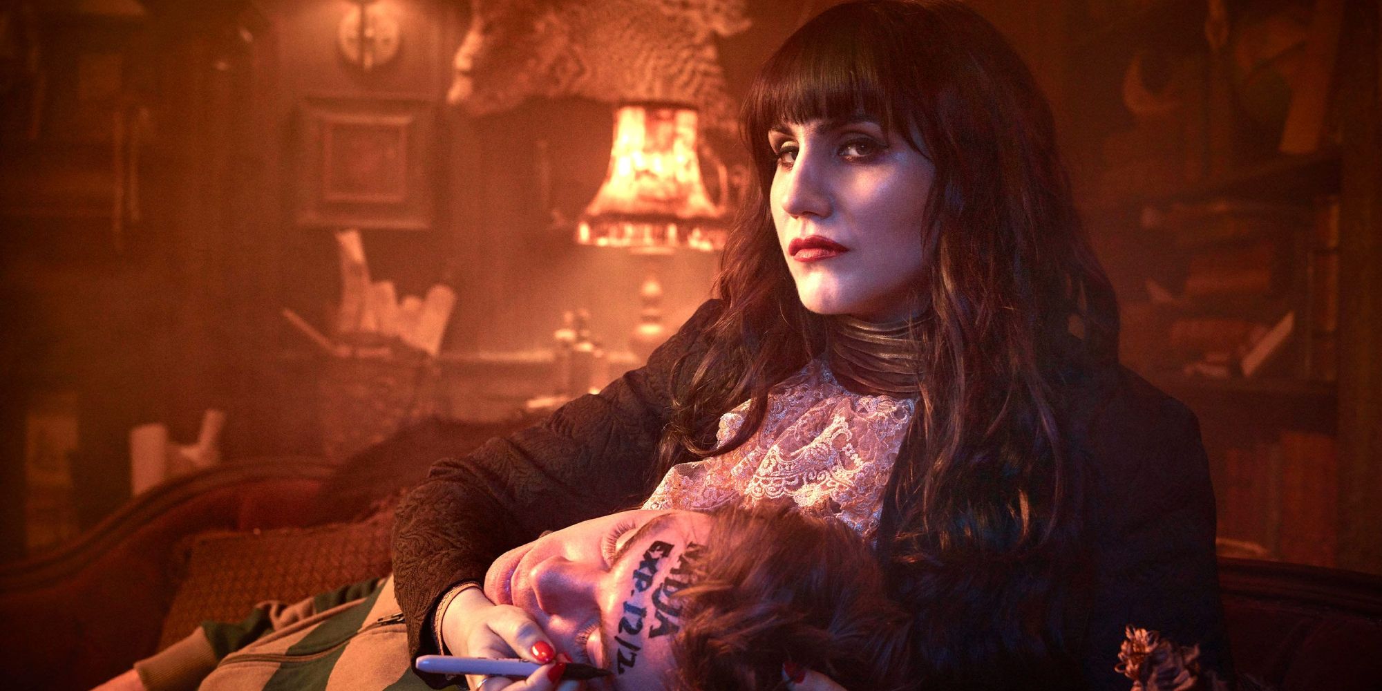 Natasia Demetriou as Nadja writing on someone's head in What We do in the Shadows.