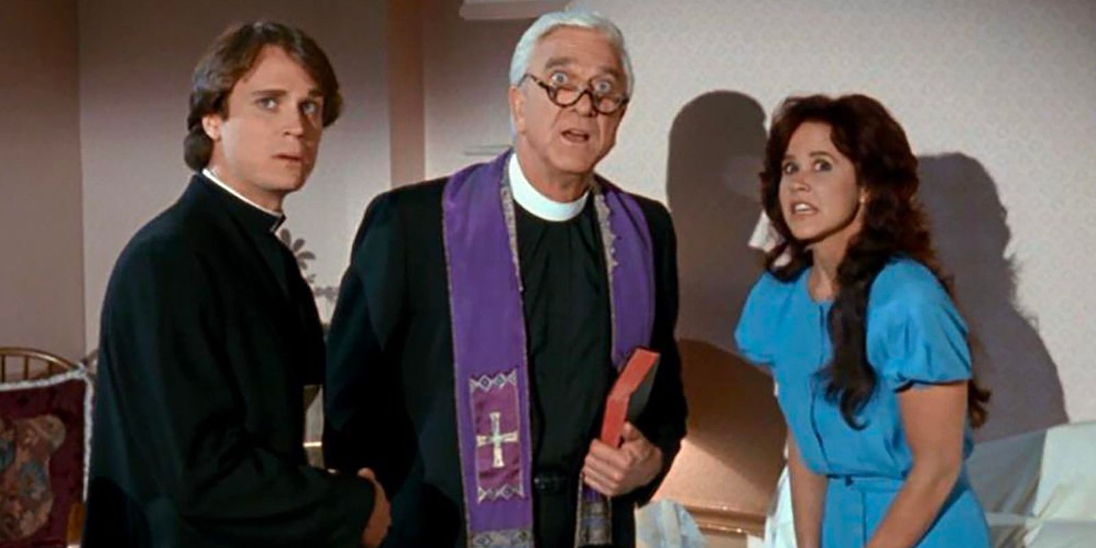 Two catholic priests shake hands as they stand next to a woman, all of them look up at something in shock.