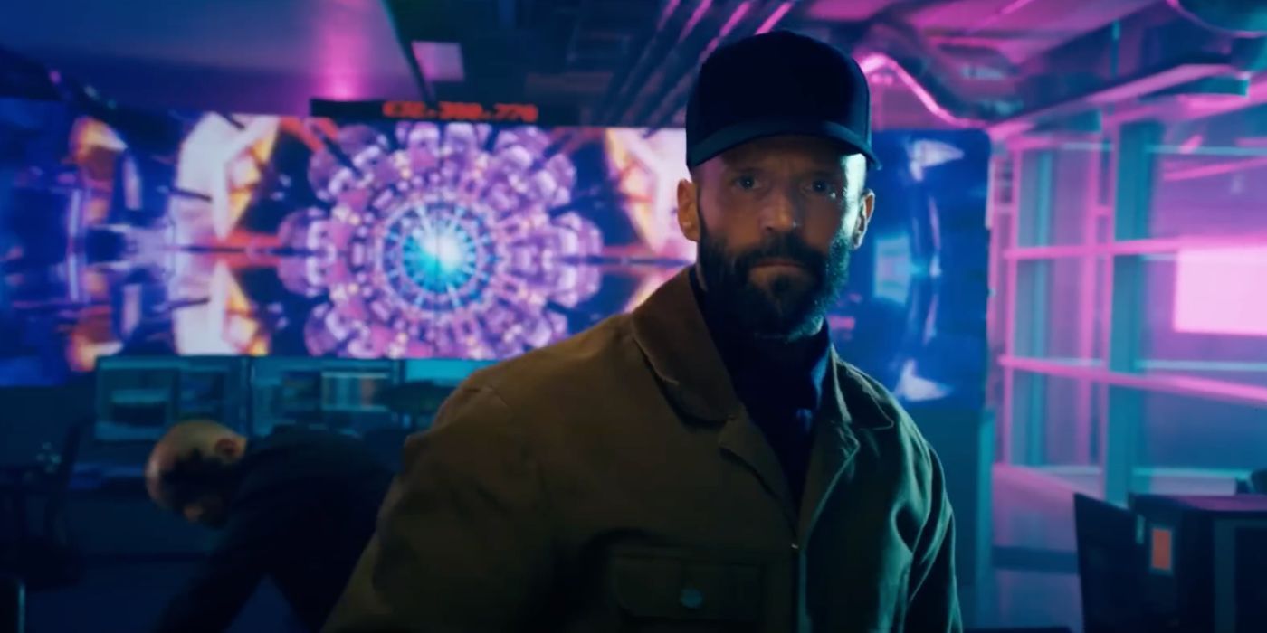 Jason Statham wearing a baseball cap in front of a kaleidoscope screen in 'The Beekeeper'