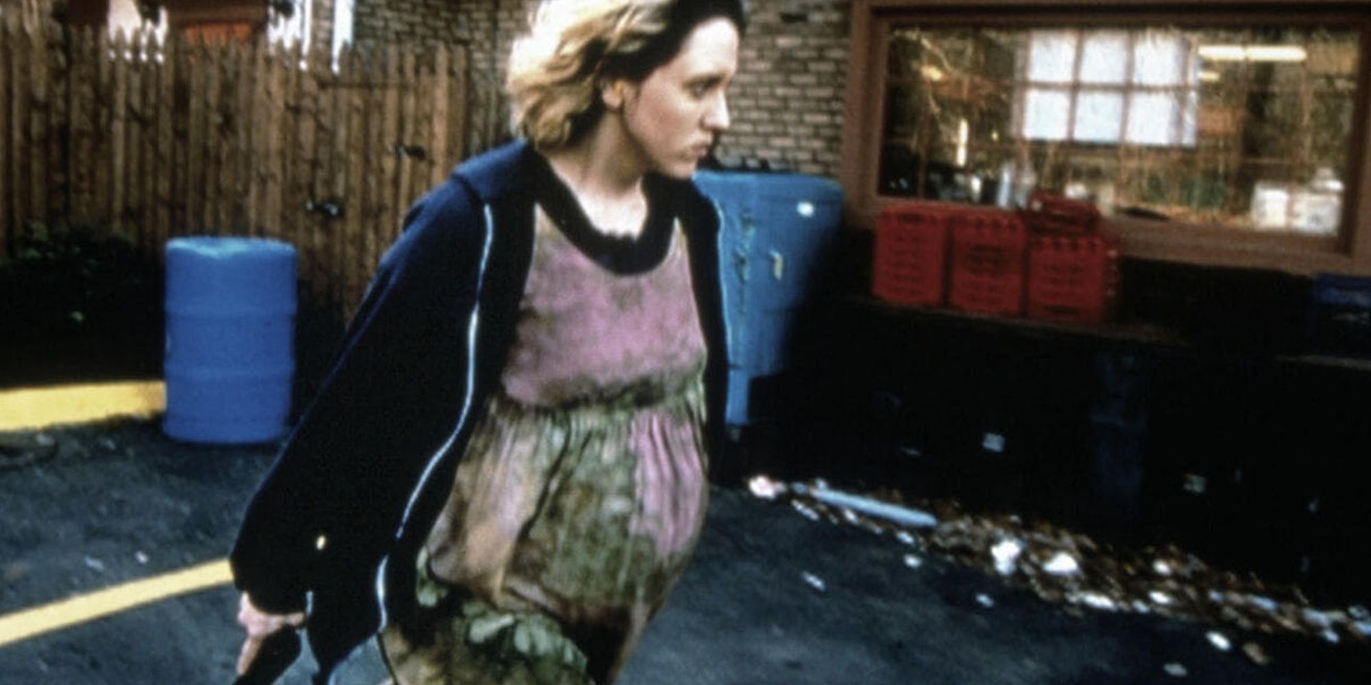 Brooke Smith dans le rôle de Dawn marchant dans une rue avec une arme à feu dans le film Série 7 : The Contenders.