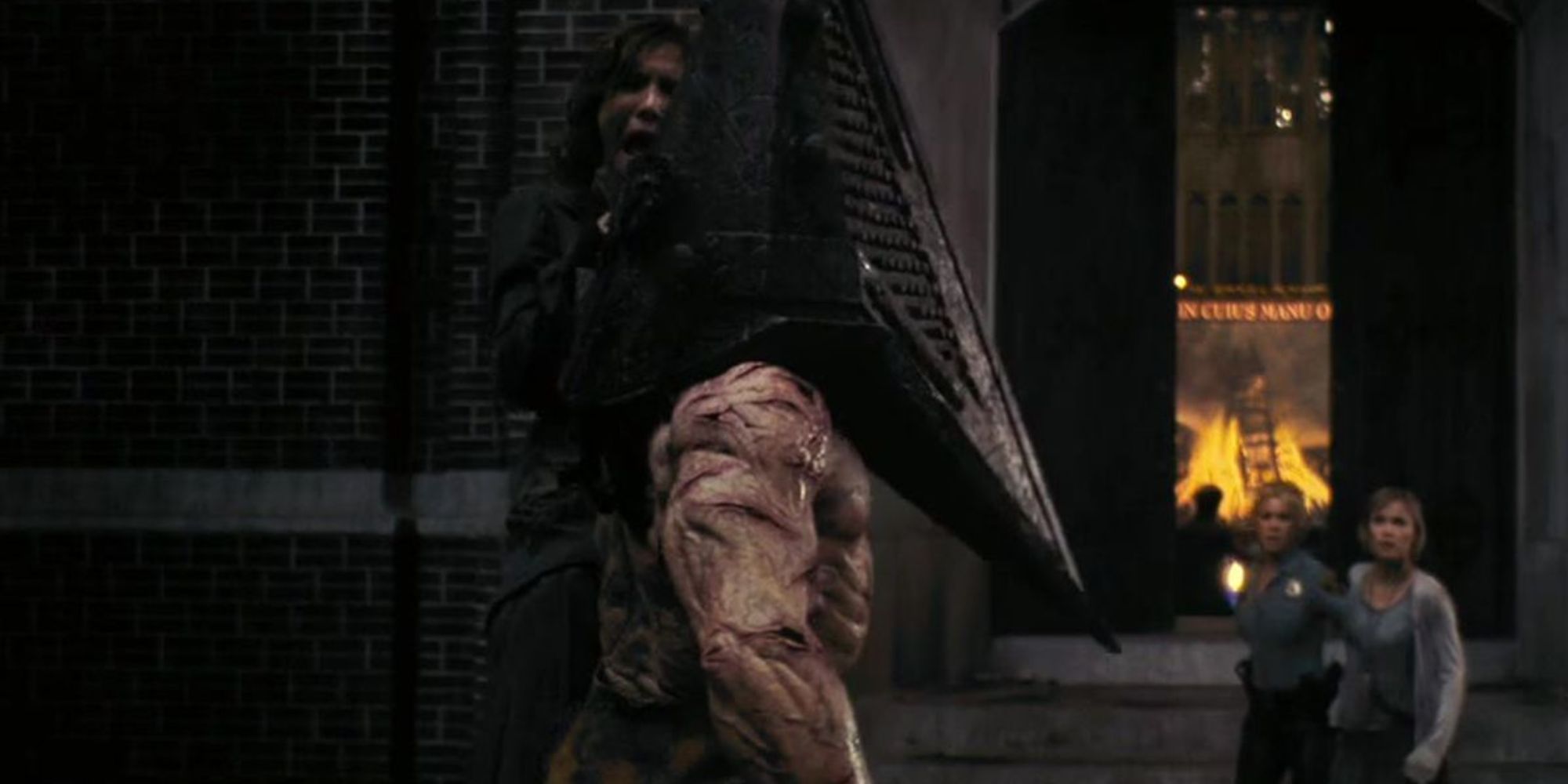 Pyramid head pins a woman to the wall